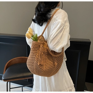 Détail du sac cabas en paille tressée avec de longues franges et texture au crochet