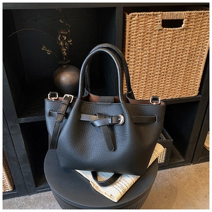 Détail du sac à main en cuir grainé noir avec boucles argentées et sangle décorative