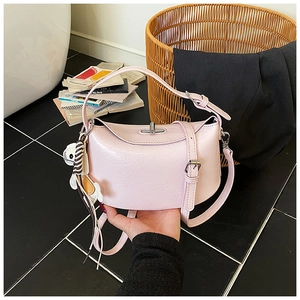 Detail of light pink half-moon bag with crinkle texture, rabbit charm and silver buckle