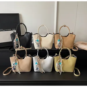 Sacs seaux élégants en plusieurs couleurs avec poignées métalliques et breloque ours