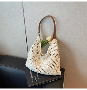 Detailed close-up of woven hollow pattern and brown leather strap on the off-white hobo bag