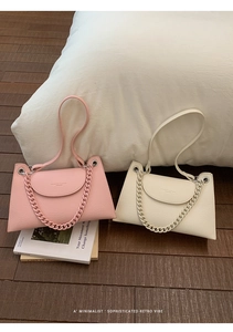 Detail of pink and beige lychee pattern leather bags with resin chains and metal accents
