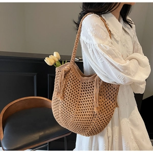 Détail du sac cabas en paille tissé main avec pompons et texture en maille ajourée
