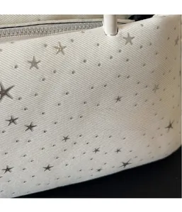 Close-up of white baguette bag with star pattern texture and metallic star details