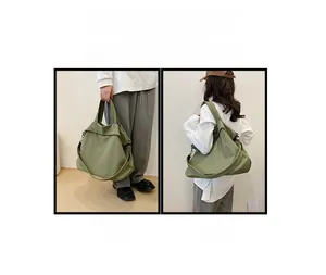 Détail du sac fourre-tout en toile verte montrant la bandoulière réglable et les options