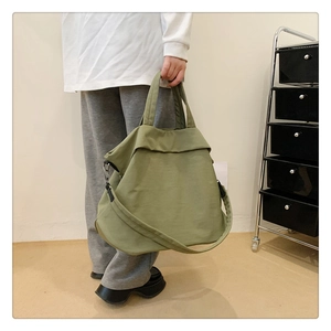 Détail du sac fourre-tout en nylon vert olive avec poignées et bandoulière réglable