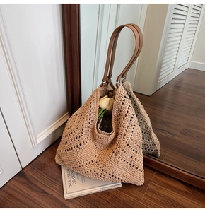 Close-up of the hollow crochet tote bag with brown leather straps and beige knit details