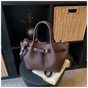 Détail d'un sac cabas en cuir marron foncé à grain litchi avec boucles vintage