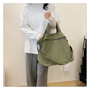 Gros plan sur le sac cabas en nylon vert olive avec rabat unique et large bandoulière