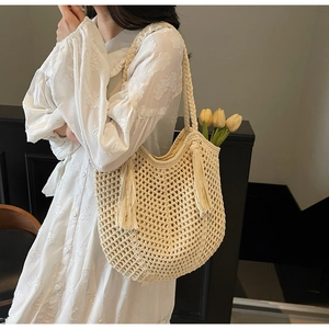 Gros plan du sac fourre-tout tissé beige avec franges et bandoulière tressée épaisse
