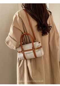 Borsa a tracolla minimalista in tela con finiture in pelle marrone indossata con trench