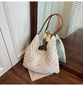 Detail of beige knit tote bag showing hollow crochet texture and brown faux leather handles