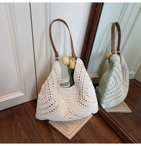 Detail of a beige knit tote bag with wavy crochet texture and a brown leather strap