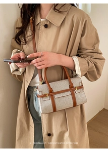 Dettaglio della tela beige e cuciture in pelle marrone di una borsa a tracolla retrò