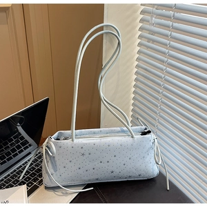 Detail view of light blue starry baguette bag with long straps and side bow accents