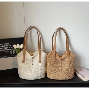 Detail of hand-woven knit tote bags with brown leather handles in beige and brown colors