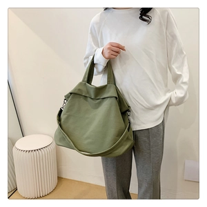 Détail du grand sac à main en toile vert olive avec bandoulière et coutures renforcées