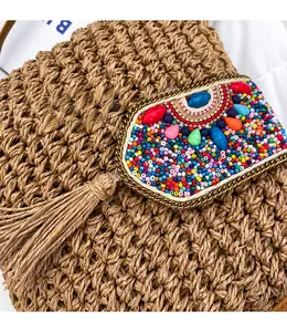 Detailed close-up of hand-woven straw bag with colorful bead accents and tassel details
