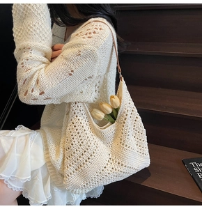 Detail of hand-woven cream tote bag with hollow knit pattern and leather strap