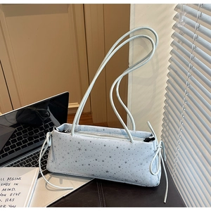 Detail of light blue star pattern bag with long strap and side tassel decoration