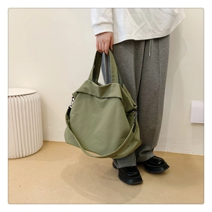 Détail du sac cabas en nylon vert olive avec doubles poignées et bandoulière réglable