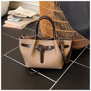 Détail du sac à main rétro bicolore montrant les finitions en cuir et les boucles élégantes