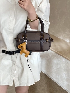 Braune Boston-Handtasche für Damen mit weißen Kontrastnähten und gelbem Pferdeanhänger-Detail
