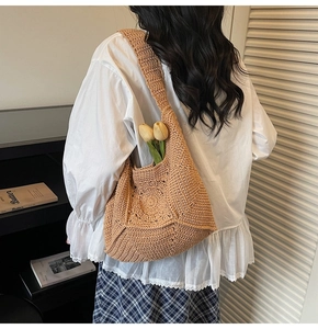 Détail d'un sac à bandoulière en coton tissé main kaki porté par un mannequin dans une pièce sobre