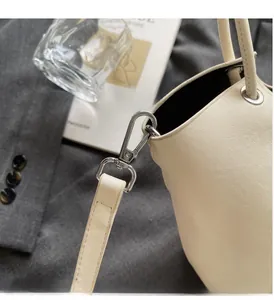 Détail du crochet en métal argenté et cuir grainé de ce sac seau élégant pour femme