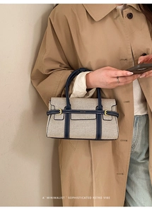 Dettaglio della borsa bicolore in tela e pelle con fibbia dorata e tracolla chic