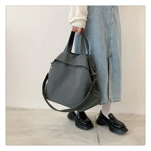 Grand sac cabas en nylon gris foncé minimaliste présenté dans un cadre décontracté
