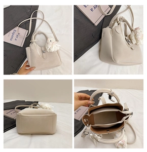Vues détaillées du sac seau beige avec breloque lapin en peluche et compartiments de rangement