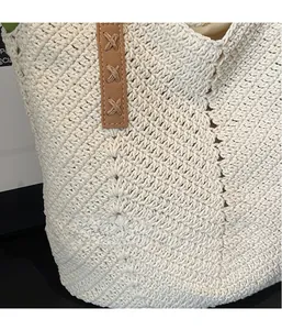 Close-up of woven straw tote bag with brown leather accents and crochet texture details