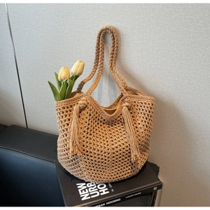 Détail du sac cabas en paille tissée avec motif en maille et longues franges décoratives