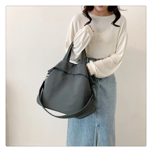 Vue détaillée d'un grand sac cabas en nylon gris foncé avec bandoulière et poignées
