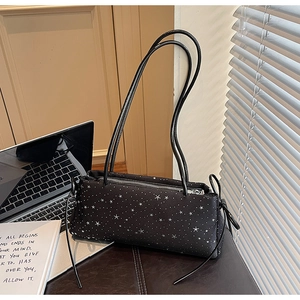 Close-up of black shoulder bag featuring white star patterns and delicate side bow details