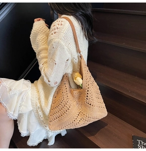 Detailed close-up of camel hollow-out crochet knit tote bag with slim brown shoulder straps