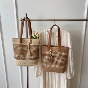 Straw tote bag with brown handles and tassels for summer beach vacation and daily use