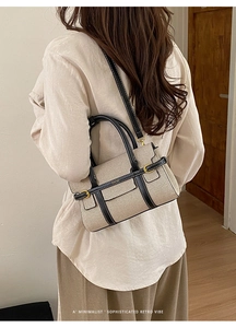 Vista posteriore della modella con borsa tote retrò bicolore in tela e pelle nera