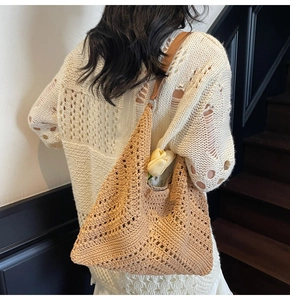 Detailed close-up showing the hollow-out geometric diamond pattern of the woven hobo bag