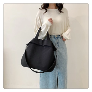 Détail du sac fourre-tout noir en nylon avec tissu haute densité et large bandoulière