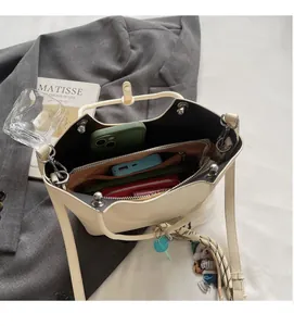 Vue intérieure du sac seau crème montrant des compartiments spacieux et poches zippées