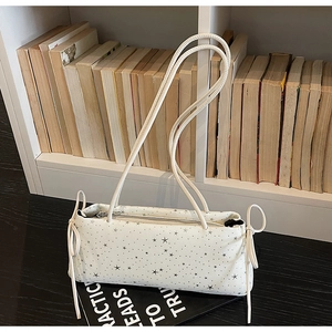 Detail of white baguette bag with star print and decorative drawstring bows