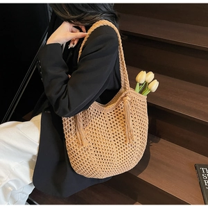 Détail du sac cabas tissé beige avec de longues franges et une poignée tressée stylée