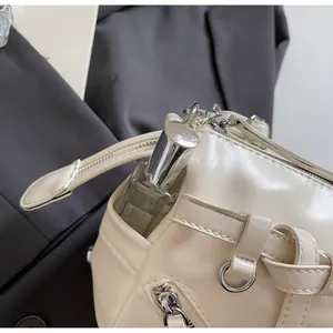 Detail of the side functional pocket on the cream faux leather crossbody shoulder bag