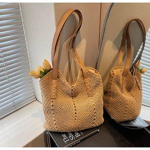 Detail showing the brown leather straps and hand-woven texture of the beige tote bag