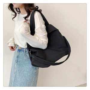 Détail d'un grand sac fourre-tout noir en nylon avec large bandoulière et anneau en D