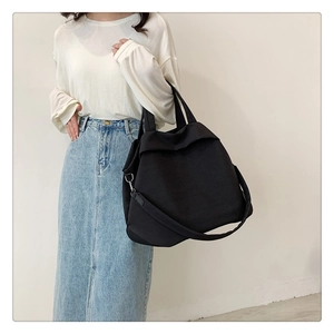 Détail d'un grand sac bandoulière en nylon noir avec une large sangle pour le loisir