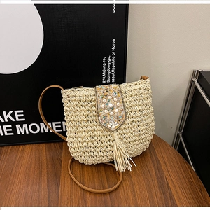 Detail of straw woven crossbody bag with colorful beads floral pattern and long tassels