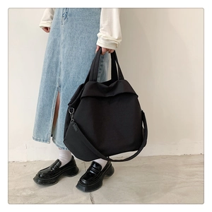 Sac fourre-tout noir minimaliste en nylon porté à l'épaule avec design spacieux pour le quotidien